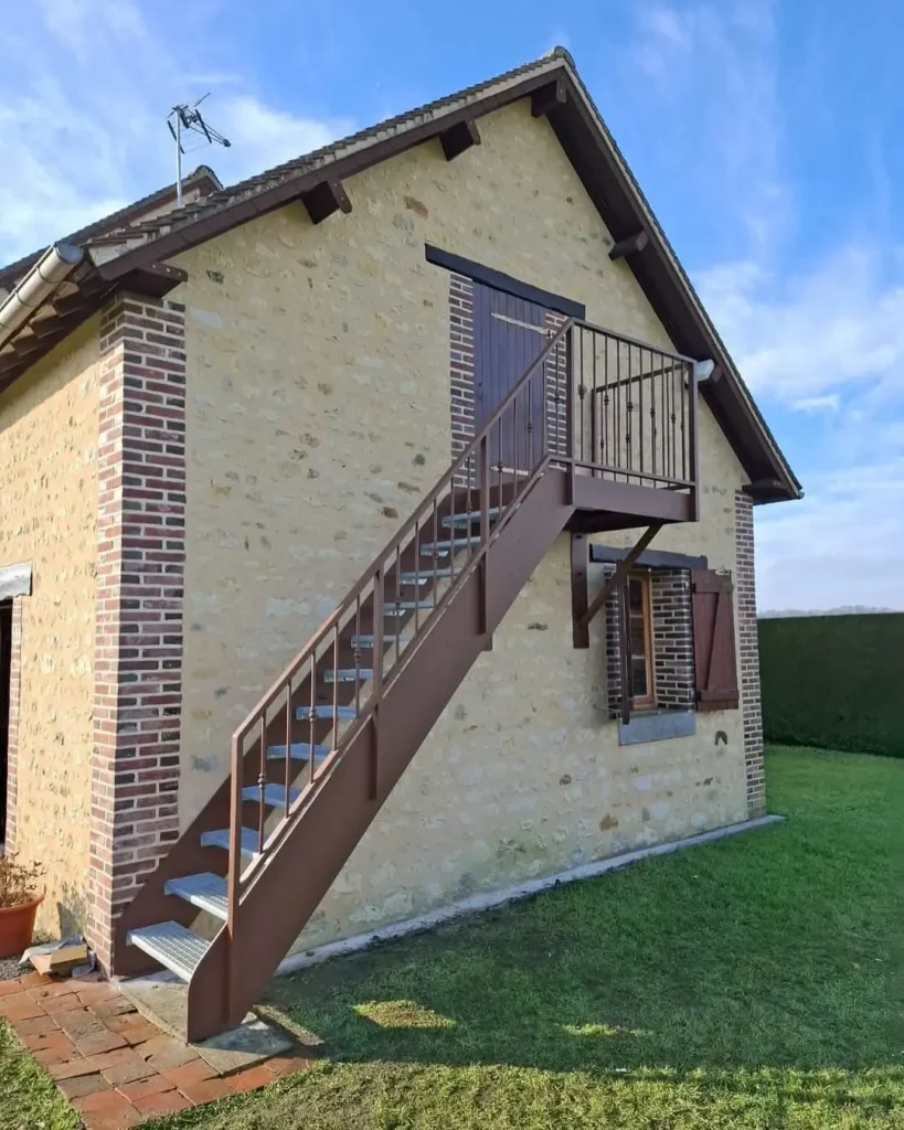 Escalier extérieur métallique sur maison en pierre