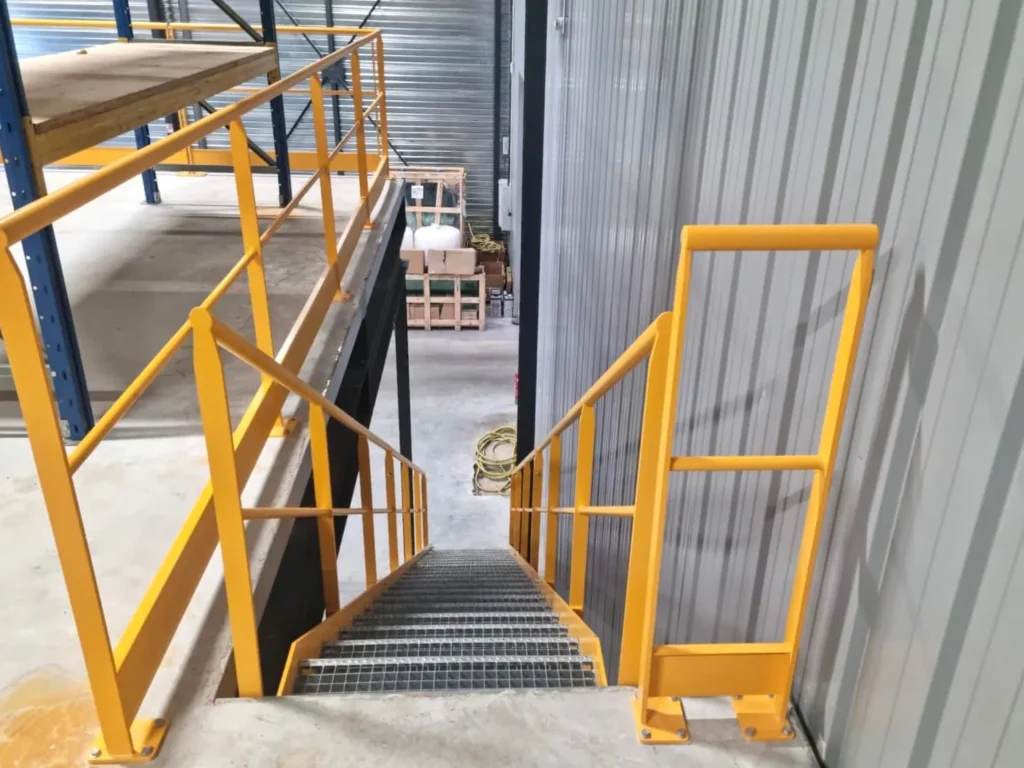 Escalier métallique jaune dans entrepôt industriel