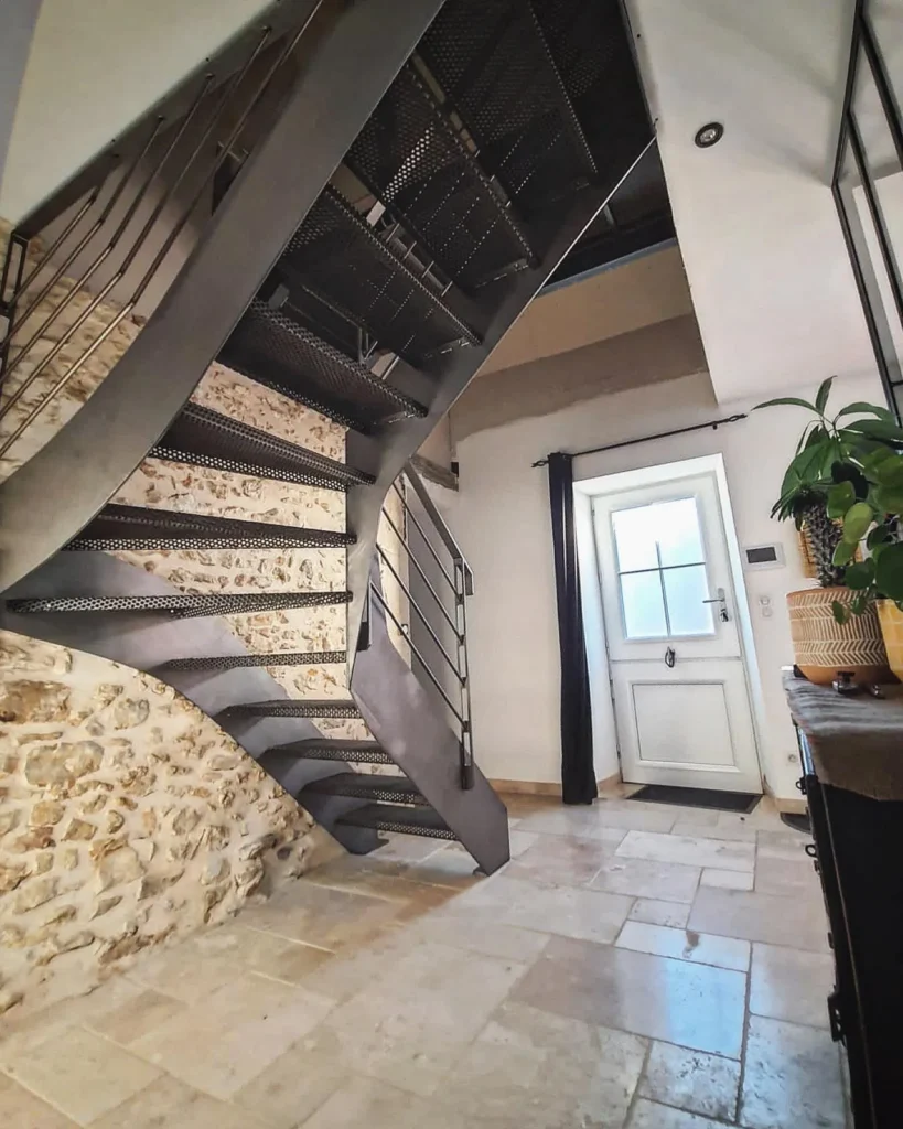 Escalier métallique moderne contre mur en pierre
