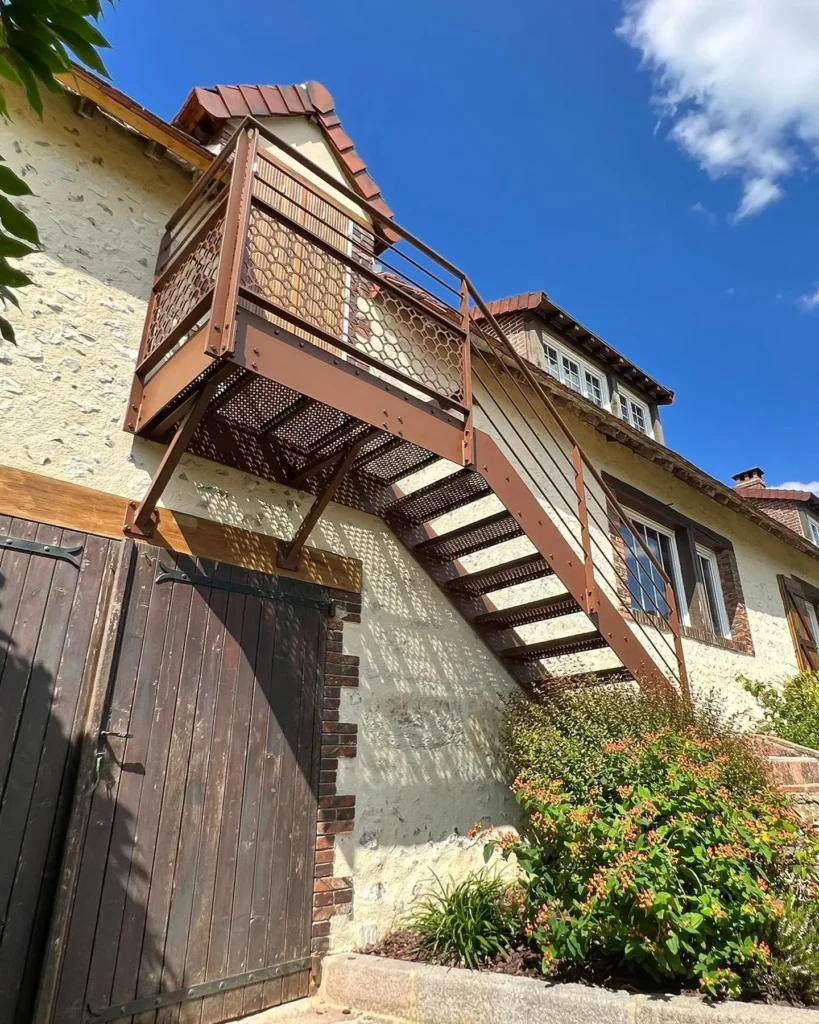 Escalier métallique extérieur sur façade de maison rustique