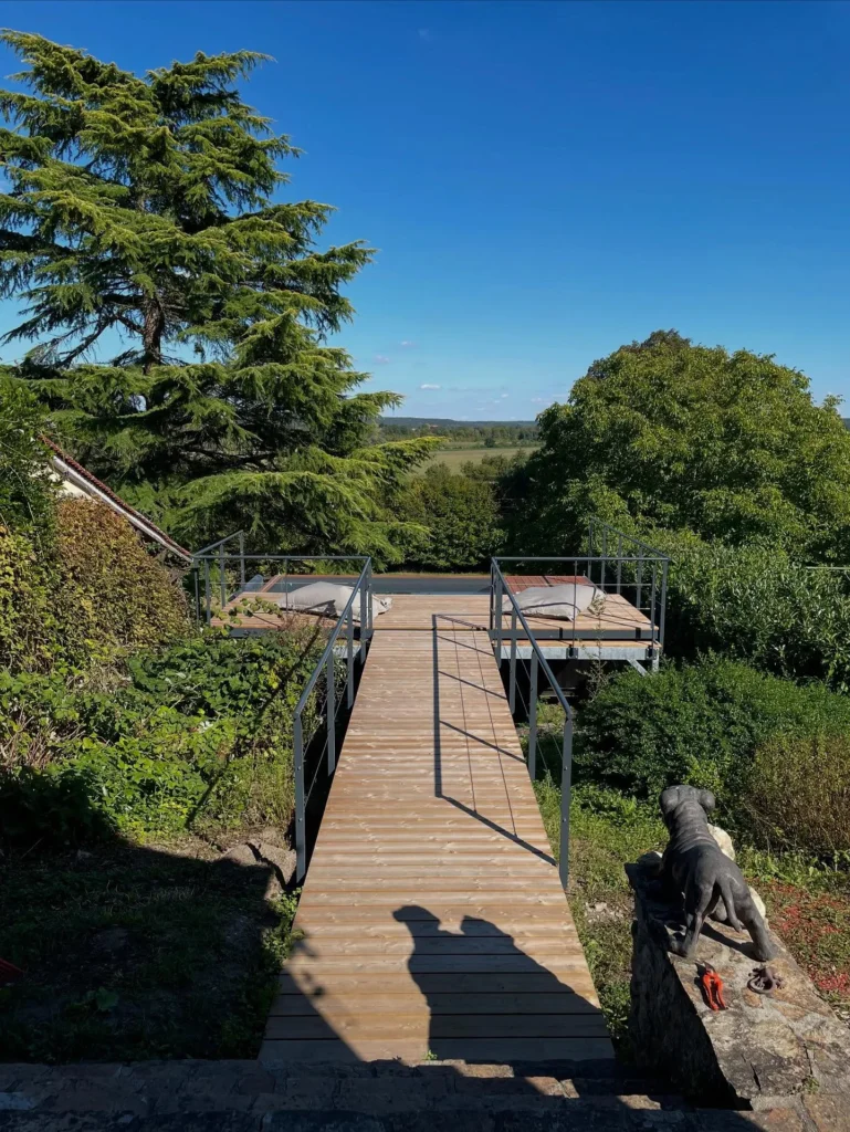 Passerelle en bois vers terrasse vue campagne