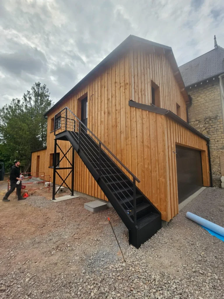 Maison en bois avec escalier extérieur métallique noir