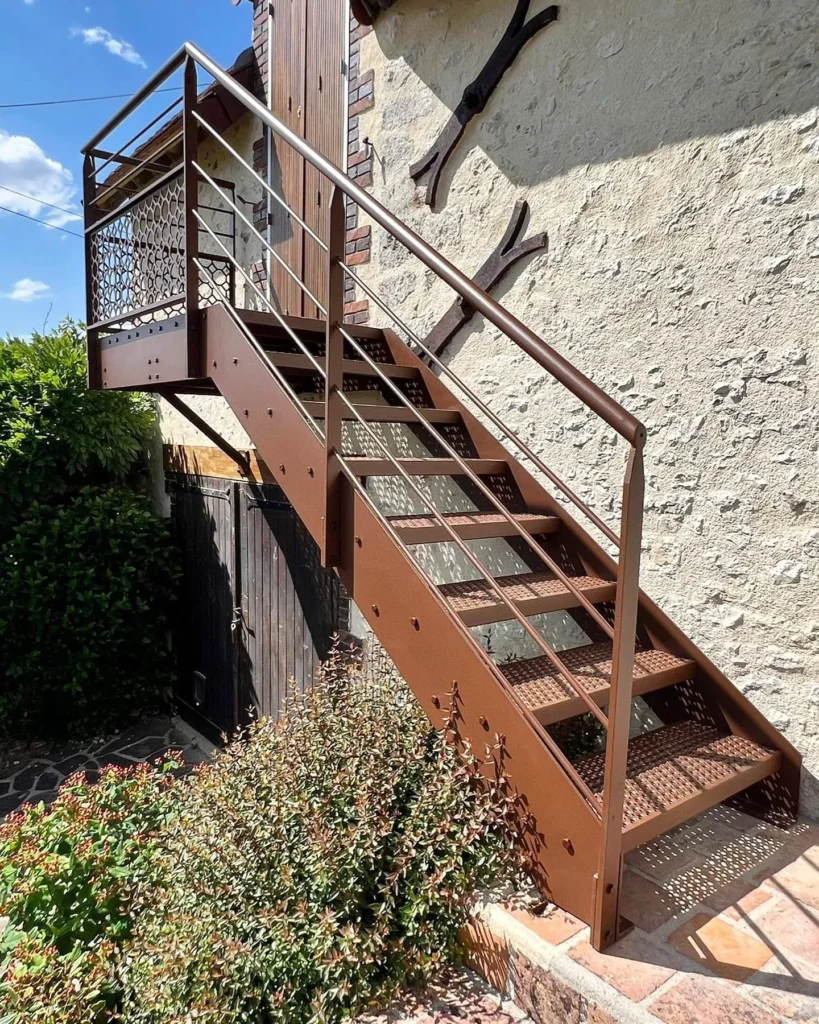 Escalier extérieur en métal brun contre maison